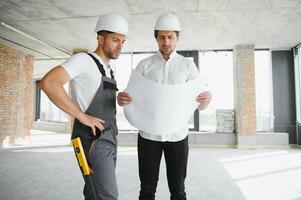 View of a Worker and architect watching some details on a construction photo