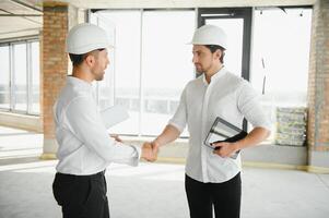 Two young man architect on a building construction site photo