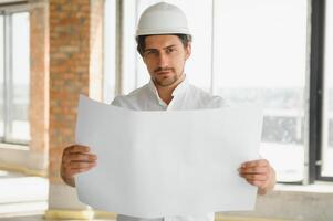 Close up engineers working on a building site holding a blueprints.Engineering and architecture concept photo