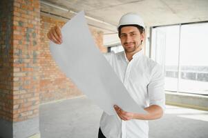 Portrait of an architect builder studying layout plan of the rooms, serious civil engineer working with documents on construction site, building and home renovation, professional foreman at work. photo
