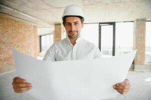 Close up engineers working on a building site holding a blueprints.Engineering and architecture concept photo