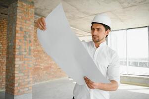 Close up engineers working on a building site holding a blueprints.Engineering and architecture concept photo