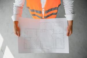 Close up engineers working on a building site holding a blueprints.Engineering and architecture concept photo