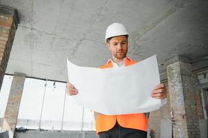 Close up engineers working on a building site holding a blueprints.Engineering and architecture concept photo