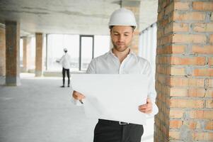 Close up engineers working on a building site holding a blueprints.Engineering and architecture concept photo