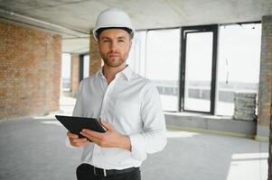 Portrait of man architect at building site. Confident construction manager wearing hardhat. Successful mature civil engineer at construction site with copy space. photo
