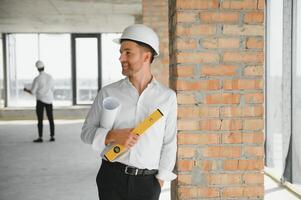 Close up engineers working on a building site holding a blueprints.Engineering and architecture concept photo