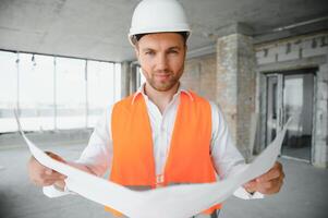 Close up engineers working on a building site holding a blueprints.Engineering and architecture concept photo