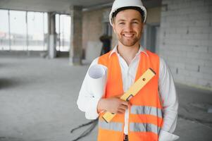 Portrait of an architect builder studying layout plan of the rooms, serious civil engineer working with documents on construction site, building and home renovation, professional foreman at work. photo