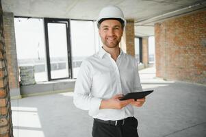 Business architect man wearing hardhat standing of a building project photo