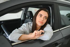 Photo of happy young woman sitting inside her new car. Concept for car rental
