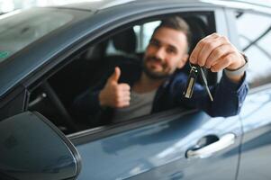Young man is choosing a new vehicle in car dealership photo