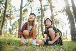 Kids exploring nature with magnifying glass. Summer activity for inquisitive child. photo