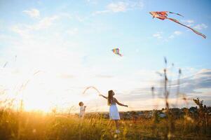 Children running with kite in the field. photo