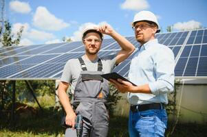 ingeniero y empresario cepillado nuevo ecología proyecto. alrededor solar panel foto