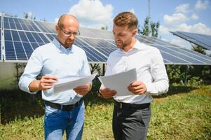ingeniero y empresario cepillado nuevo ecología proyecto. alrededor solar panel foto
