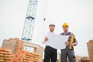 Structural engineer and foreman worker discuss, plan working for the outdoors building construction site photo
