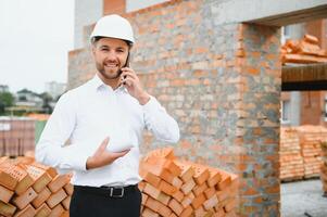Engineering Consulting People on construction site holding blueprint in his hand. Building inspector. Construction site check drawing and business workflow of new building. photo