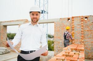 Engineering Consulting People on construction site holding blueprint in his hand. Building inspector. Construction site check drawing and business workflow of new building. photo