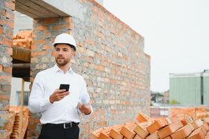 Engineering Consulting People on construction site holding blueprint in his hand. Building inspector. Construction site check drawing and business workflow of new building. photo