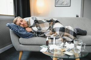 Sick man lying on sofa at home. photo