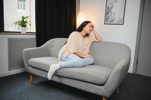 Sad tired young woman touching forehead having headache migraine or depression, upset frustrated girl troubled with problem feel stressed cover crying face with hand suffer from grief sorrow concept. photo