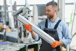 Factory for aluminum and PVC windows and doors production. Manual worker assembling PVC windows and doors photo