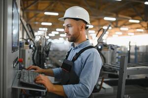 Operator wearing safety hat behind control panel on a factory photo