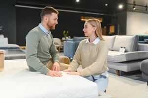 Married couple chooses the best new sofa in a furniture store photo
