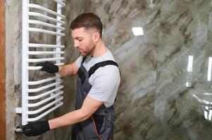 plumber service. handyman installing heating radiator photo