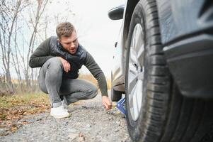 Man with broken car in the middle of the road. photo