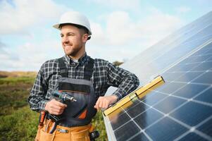 Professional worker installing solar panels on the metal construction, using different equipment, wearing helmet. Innovative solution for energy solving. Use renewable resources. Green energy. photo