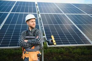 Professional worker installing solar panels on the metal construction, using different equipment, wearing helmet. Innovative solution for energy solving. Use renewable resources. Green energy. photo