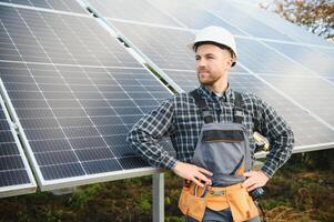 Professional worker installing solar panels on the metal construction, using different equipment, wearing helmet. Innovative solution for energy solving. Use renewable resources. Green energy. photo