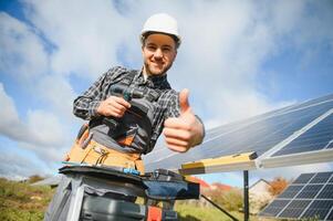 Professional worker installing solar panels on the metal construction, using different equipment, wearing helmet. Innovative solution for energy solving. Use renewable resources. Green energy. photo