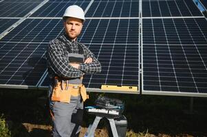 Professional worker installing solar panels on the metal construction, using different equipment, wearing helmet. Innovative solution for energy solving. Use renewable resources. Green energy. photo