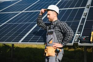 Professional worker installing solar panels on the metal construction, using different equipment, wearing helmet. Innovative solution for energy solving. Use renewable resources. Green energy. photo