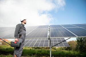 Professional worker installing solar panels on the metal construction, using different equipment, wearing helmet. Innovative solution for energy solving. Use renewable resources. Green energy. photo