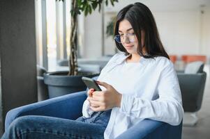 Smiling girl student study online with skype teacher, happy young woman learn language listen lecture watch webinar write notes look at laptop sit in cafe, distant education photo