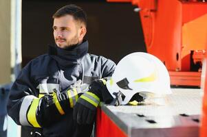 Fireman firefighter in action standing near a firetruck. Emergency safety. Protection, rescue from danger. photo