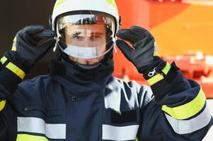 Fireman firefighter in action standing near a firetruck. Emergency safety. Protection, rescue from danger. photo