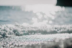 Abstract nature summer ocean sunset sea background. Small waves on water surface in motion blur with bokeh lights from sunrise. Holiday, vacation and recreational background concept. photo