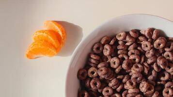 A close up of a complete breakfast of multigrain cereal, orange slices. photo