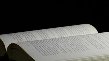 Pages of a open book with words, phrases and texts in castillian, rotating video