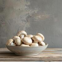 White Button Mushrooms in a Gray Bowl on a Wooden Table photo