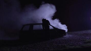 Unrecognizable fireman combating a fire of a burning car accident. Firefighter fighting flames. video