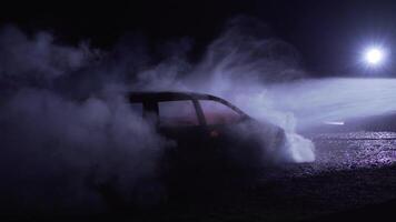 Unrecognizable fireman silhouette combating a fire of a burning car accident. Firefighter concept video