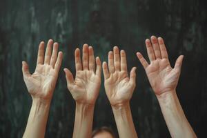 Hands Raised In Solidarity Against a Dark Background photo