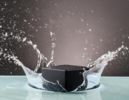 empty black podium mockup with water splash on a grey gradient background for product display photo