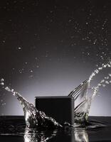 empty black podium mockup with water splash on a black gradient background for product display photo
